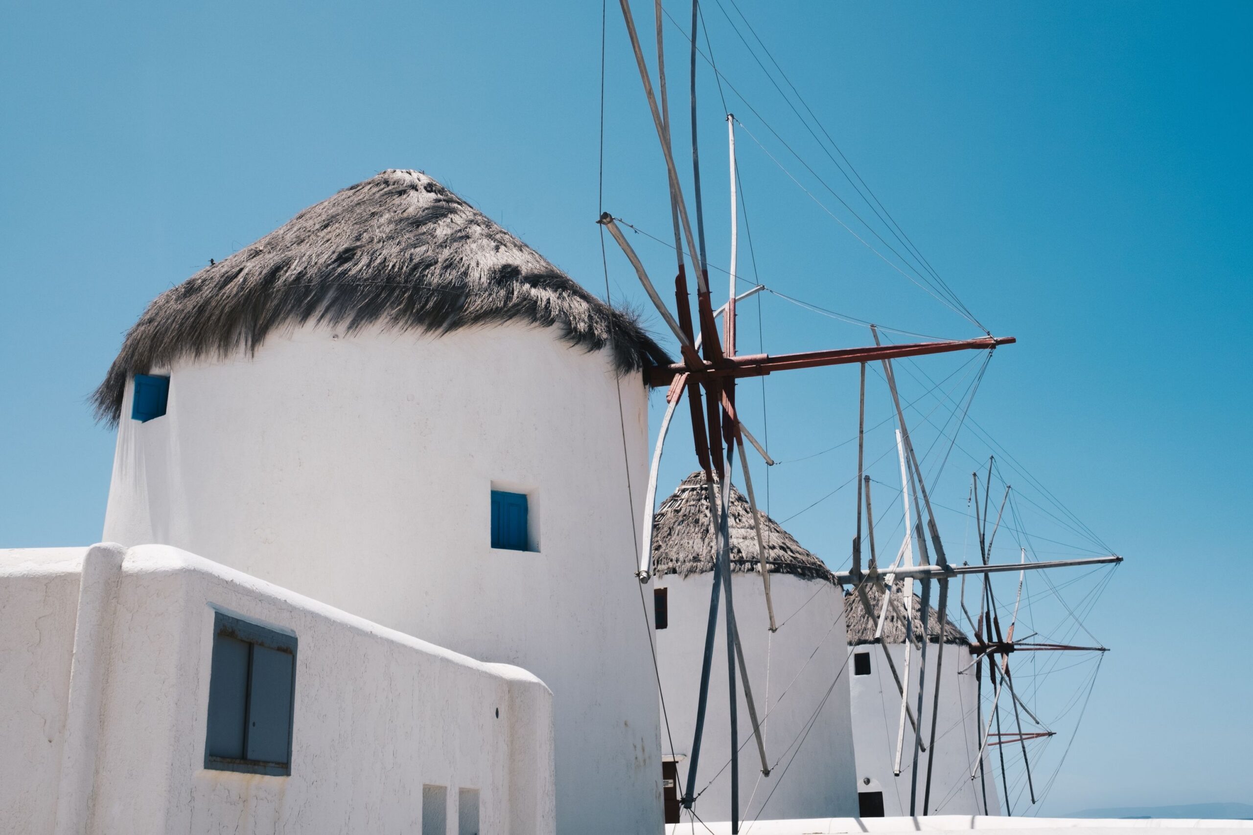 Iconic,White,Windmills,With,Thatched,Roofs,Under,A,Clear,Blue